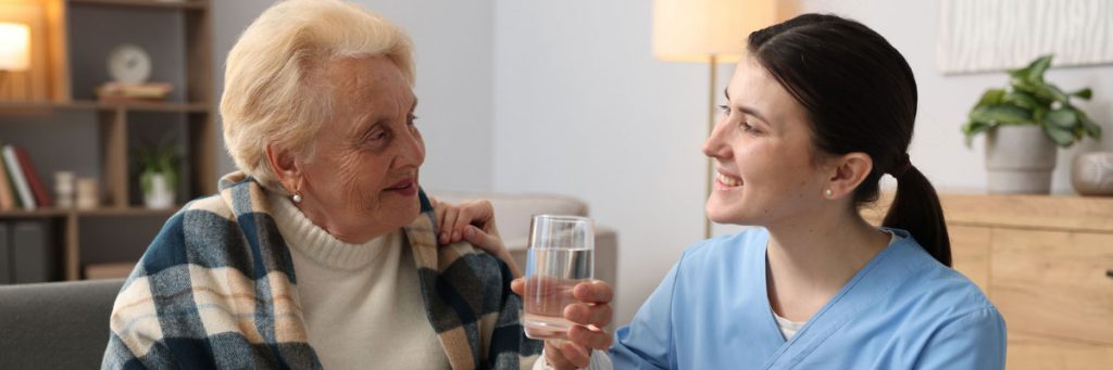 A health and social worker helping an elderly person.