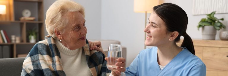 A health and social worker helping an elderly person.
