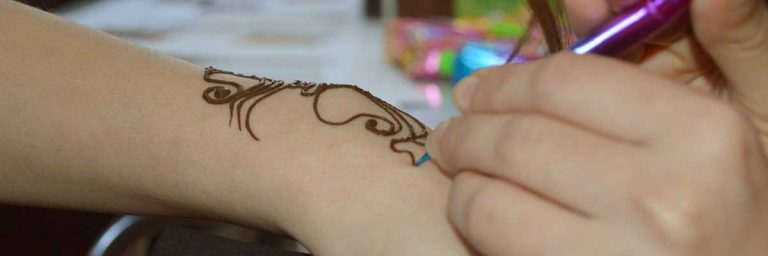 applying henna onto hand
