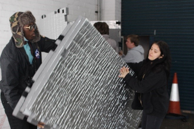 people moving large foil object