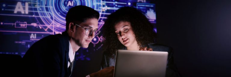 Two people looking at a laptop together.