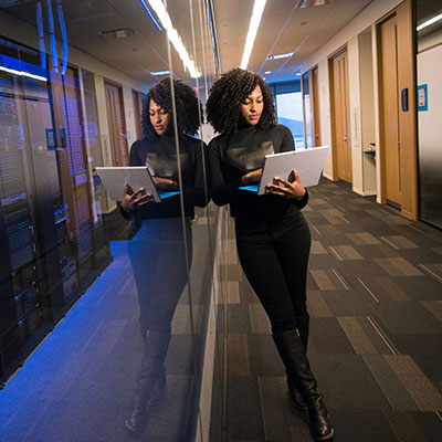 woman-using-laptop-next-to-servers