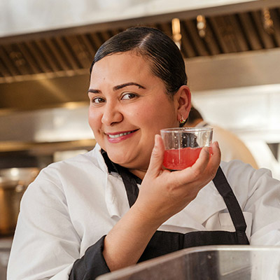female-server-smiling-while-holding-drink