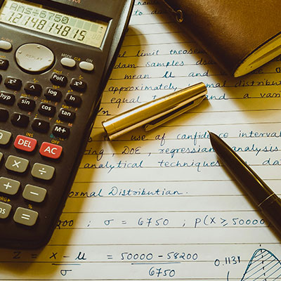 calculator-next-to-notebook-pen-paper-with-maths