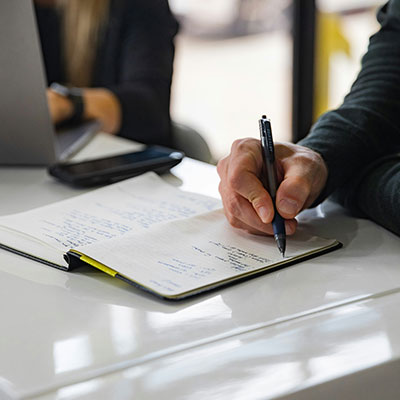 person-writing-notes-in-notebook