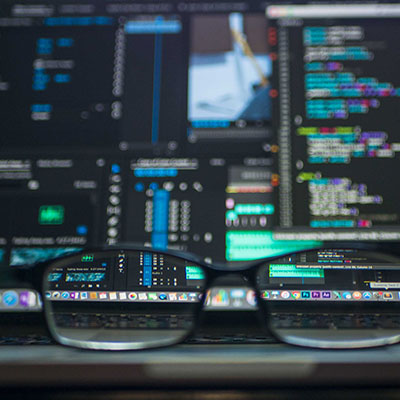 code-on-monitors-with-glasses-in-front