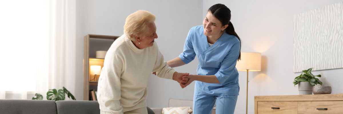 Young woman helping elderly woman in her home.