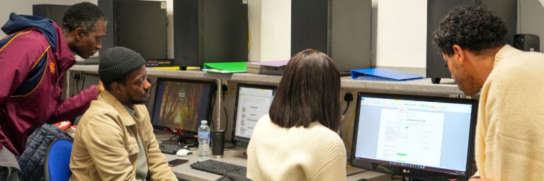 People sitting facing computers in a computer room